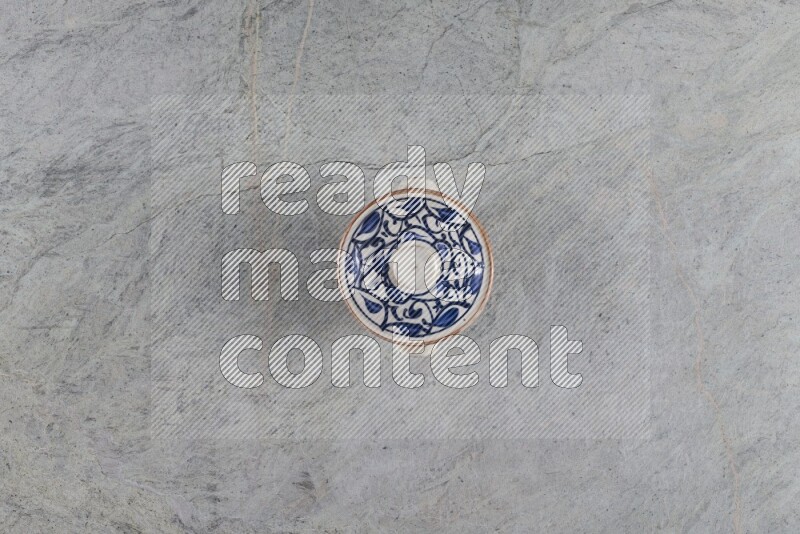 A multicolored pottery pot with its lid on grey marble background