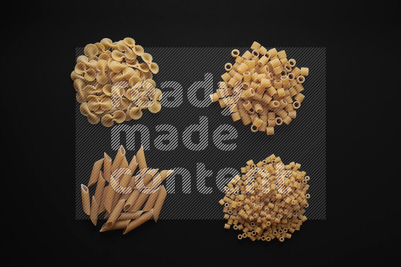 Different pasta types in bunches on black background