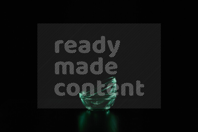 Glassware with rim light in green against black background