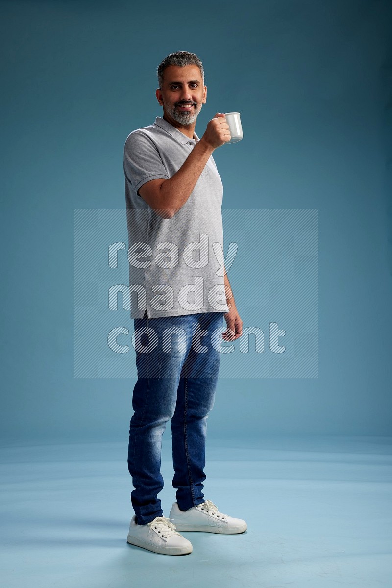 Man Standing drinking coffee on blue background