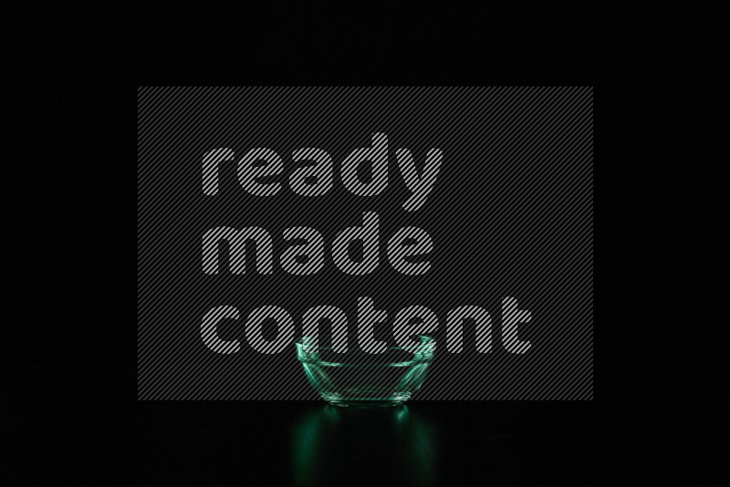 Glassware with rim light in green against black background