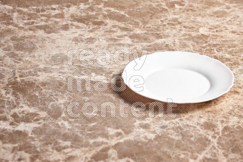 A white ceramic circular plate on beige marble background