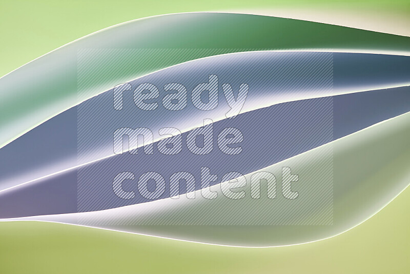 هذه الصورة تعرض تكوين فن الورق التجريدي مع منحنيات ورقية بتدرجات اللون الأخضر المكونه بواسطة الضوء الملون