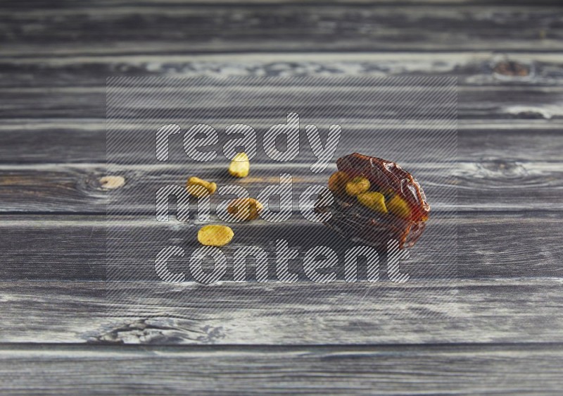 pistachio stuffed madjoul date on a wooden grey background