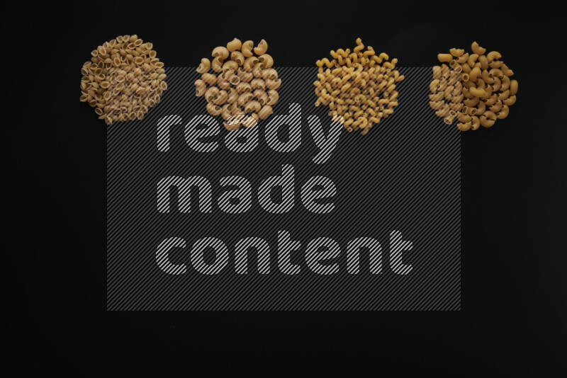 Different pasta types in 4 bunches on black background