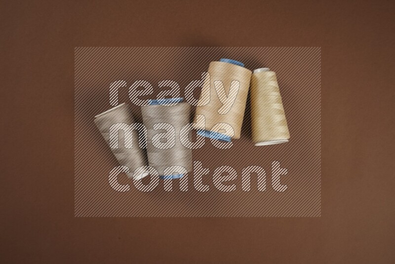 مجموعة من أدوات الخياطة والتفصيل بنية اللون على خلفية بنية