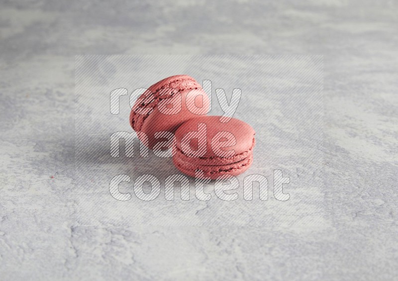 45º Shot of two Pink Raspberry macarons  on white  marble background