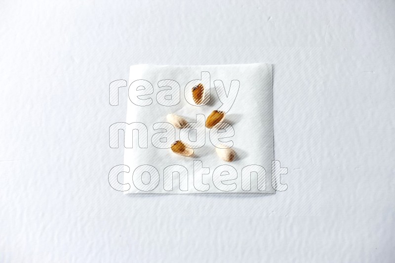 Pistachio peels on a piece of paper on a white background in different angles