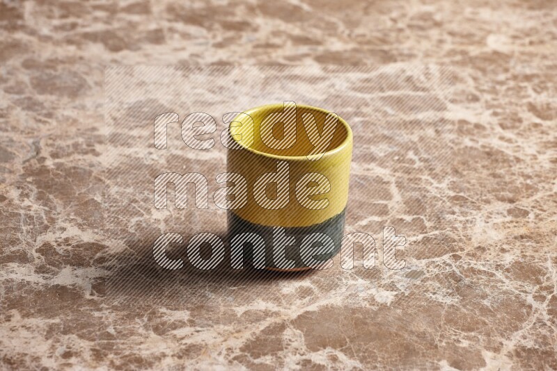 كأس فخاري متعدد الألوان على خلفية من الرخام البيج