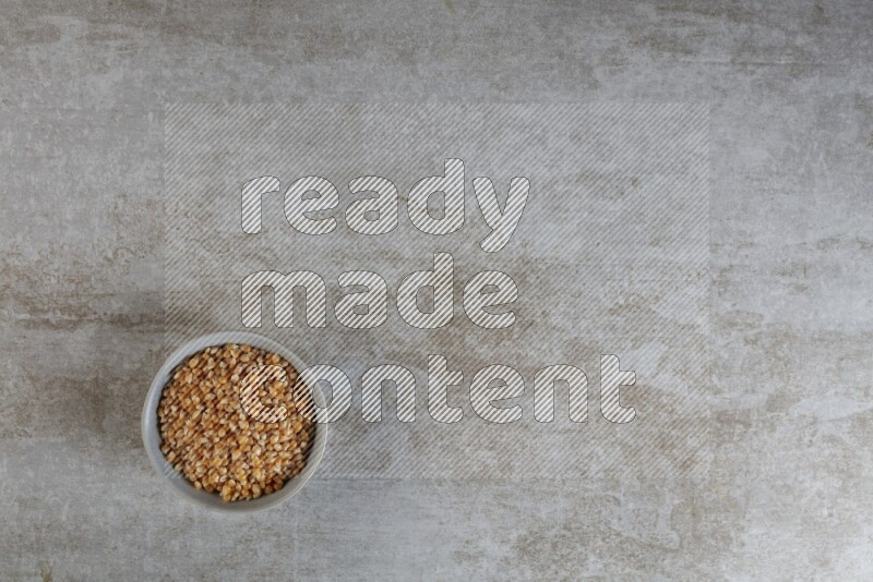 corn kernel in a gray ceramic bowl on a grey textured countertop