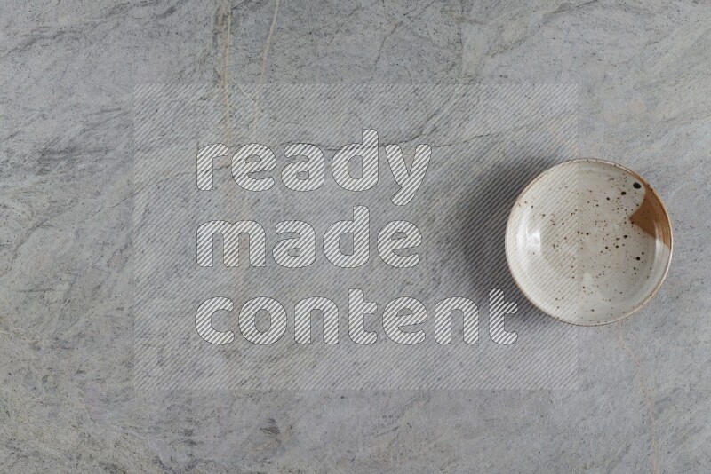 A multicolored pottery plate on grey marble background