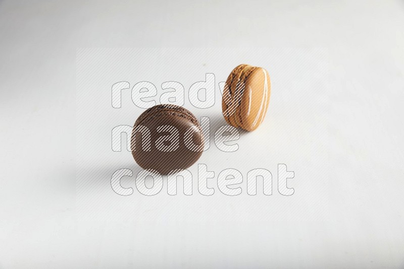 45º Shot of of two assorted Brown Irish Cream, and Brown Dark Chocolate macarons on white background