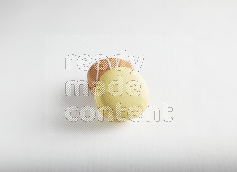 45º Shot of of two assorted Brown Irish Cream, and Yellow Lime macarons on white background