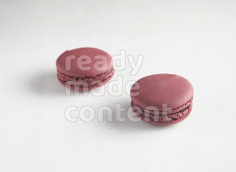 45º Shot of two Red Cherry macarons on white background