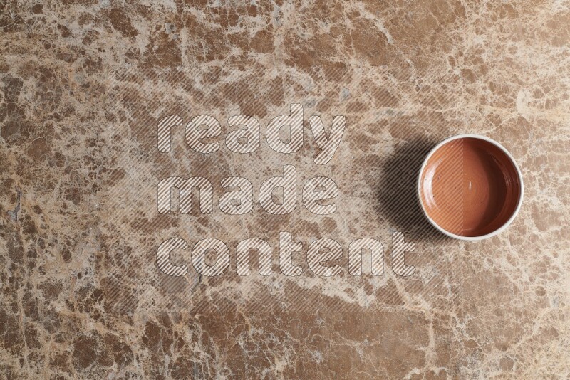 Top View Shot Of A Brown Pottery bowl On beige Marble Flooring