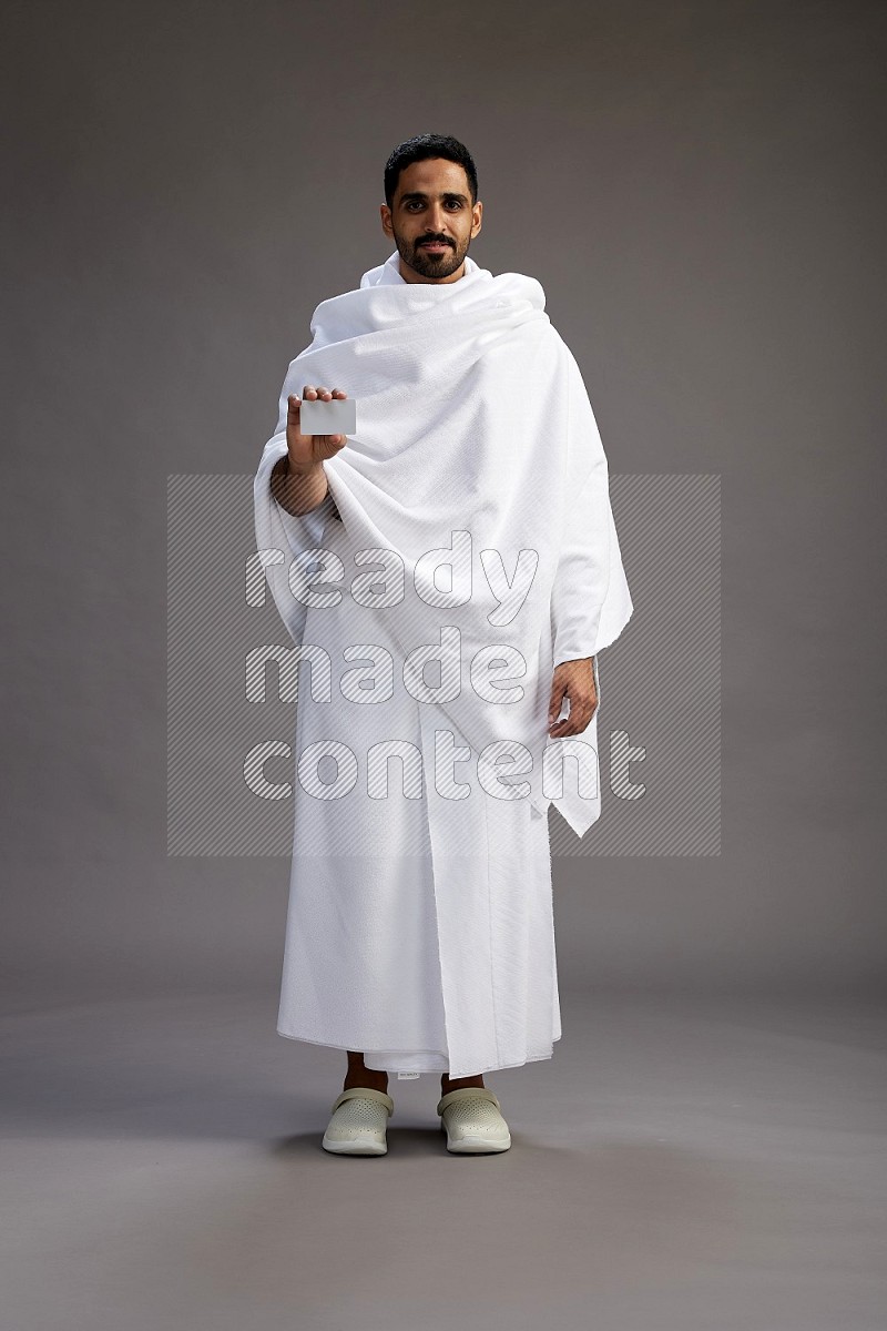 A man wearing Ehram Standing holding ATM card on gray background