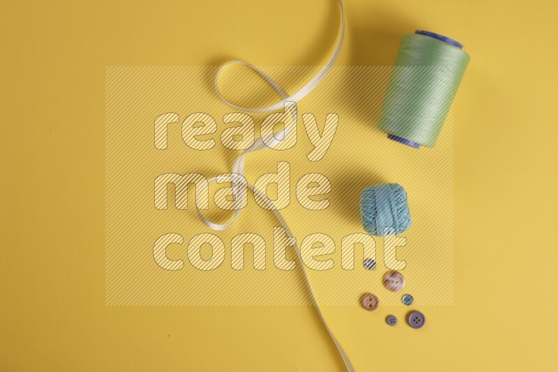 A green collection of sewing and tailoring tools arranged on a yellow background