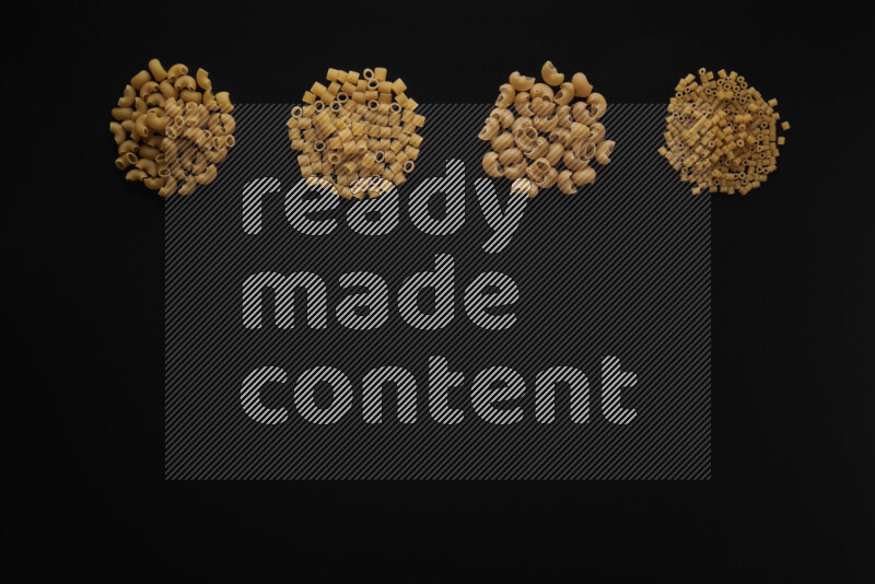 Different pasta types in 4 bunches on black background