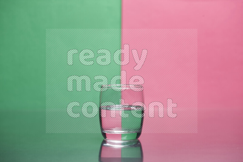 تظهر الصورة أواني زجاجية ممتلئة بالماء موضوعة على خلفية من اللونين الأخضر والوردي