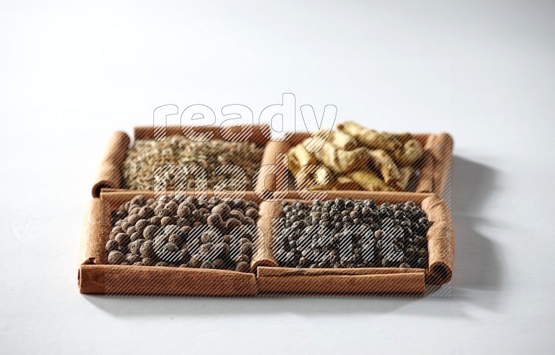 4 squares of cinnamon sticks full of cumin, turmeric fingers, allspice and black pepper on white flooring