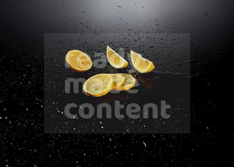 Lemon slices with water drops, and droplets on black background