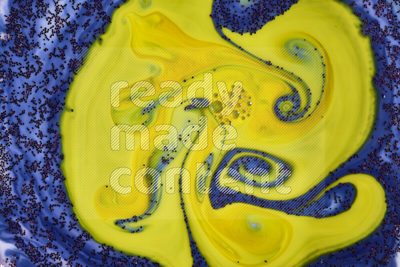 A close-up of sparkling purple glitter scattered on swirling blue and yellow background