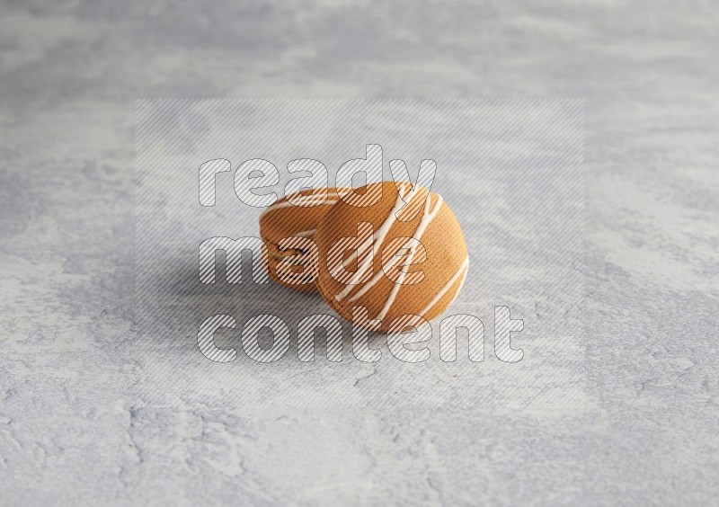 45º Shot of two Brown Irish Cream macarons  on white  marble background