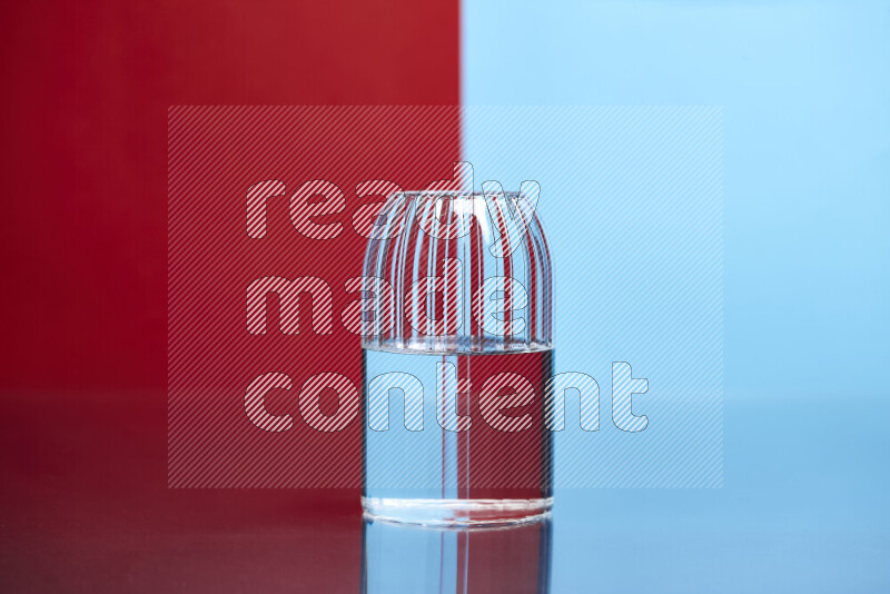 The image features a clear glassware filled with water, set against red and light blue background