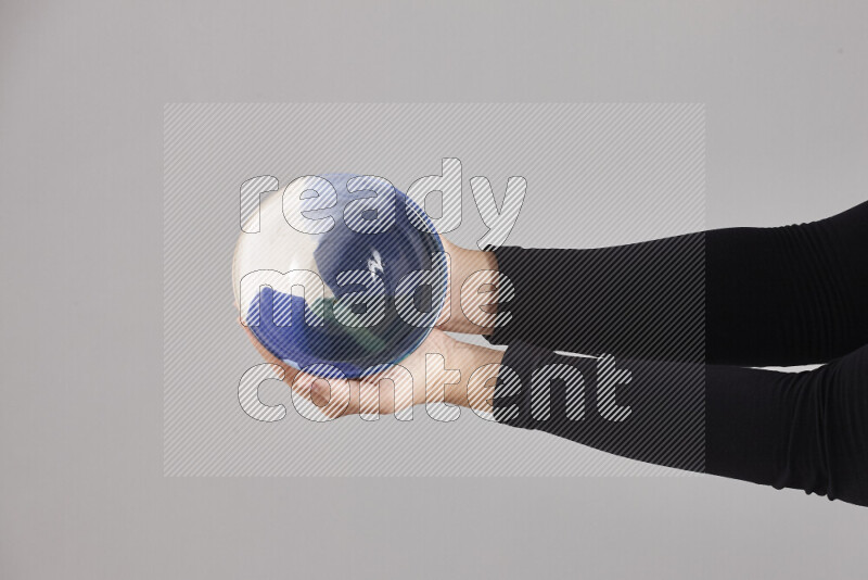 A woman in black abaya holding different pottery essentials in different positions