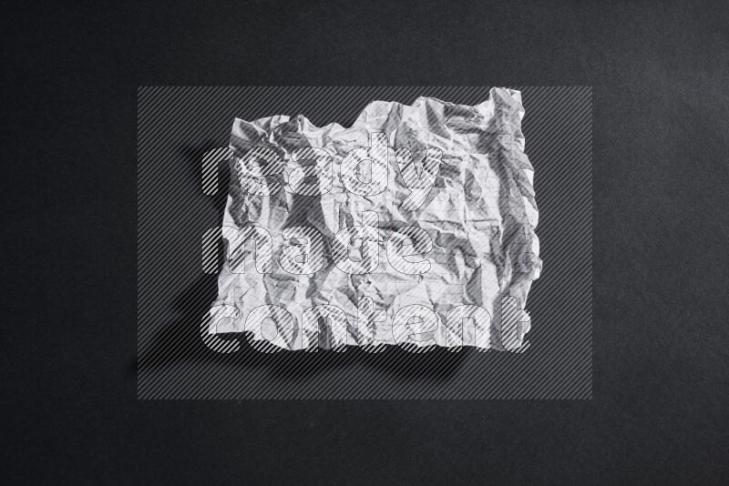 Crumpled notebook sheet on black background