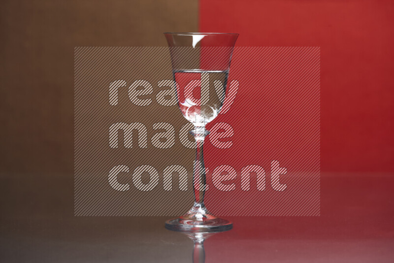 The image features a clear glassware filled with water, set against brown and red background