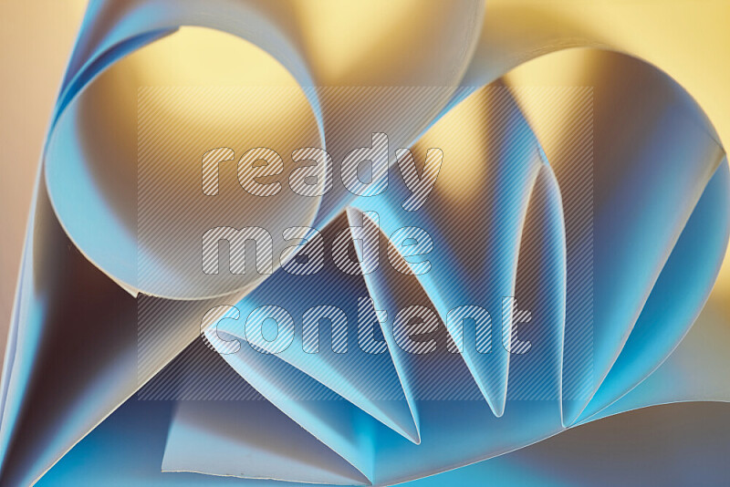An artistic display of paper folds creating a harmonious blend of geometric shapes, highlighted by soft lighting in blue and warm tones