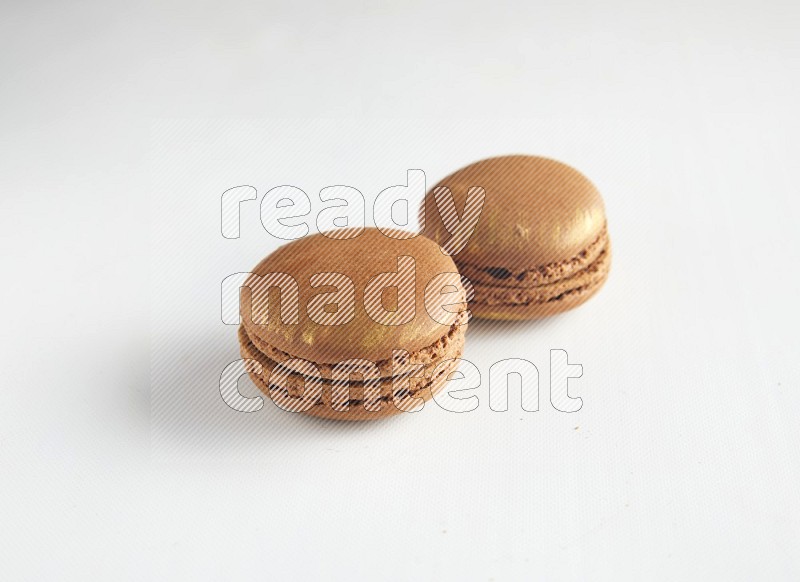45º Shot of two Brown Coffee macarons on white background