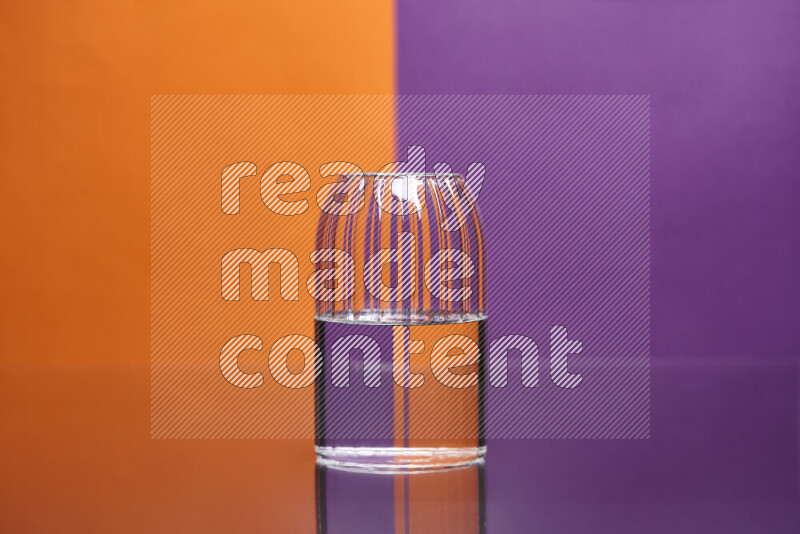 The image features a clear glassware filled with water, set against orange and purple background
