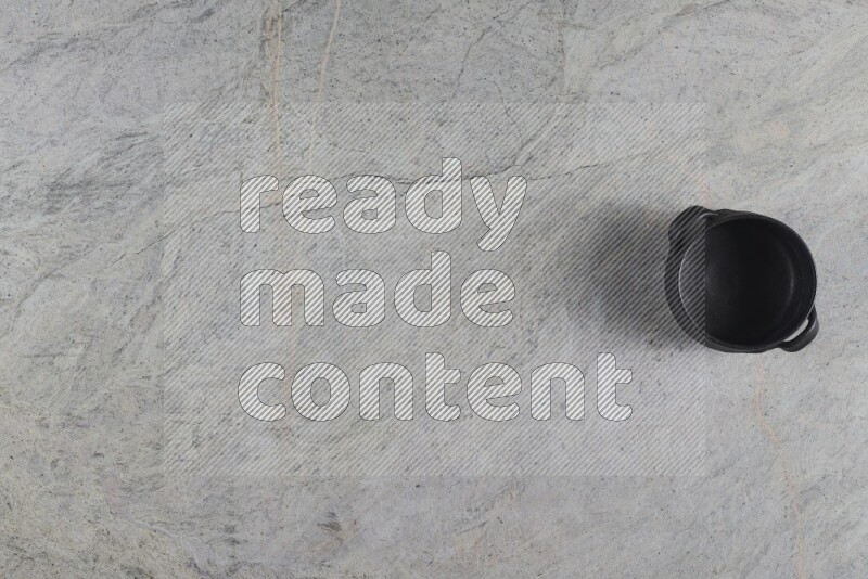 A black pottery bowl on grey marble background