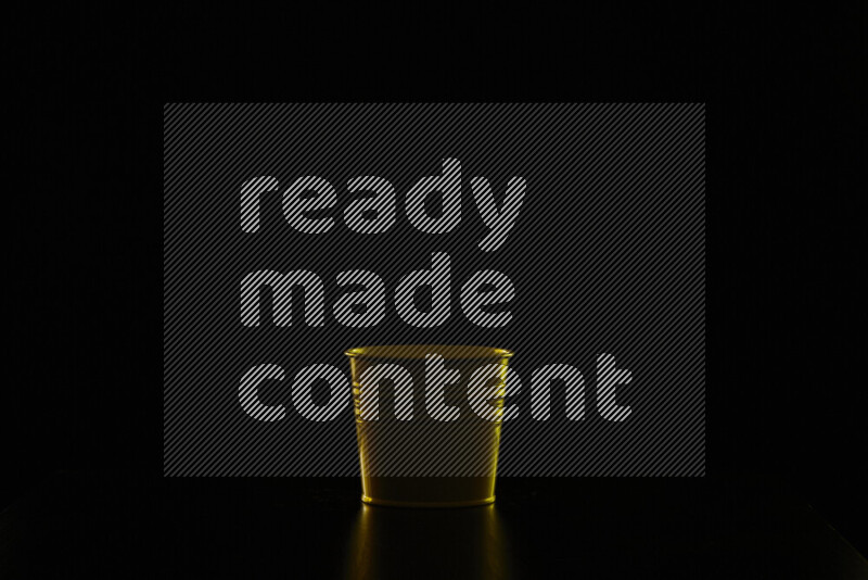 A plant pot with colored rim light against black background