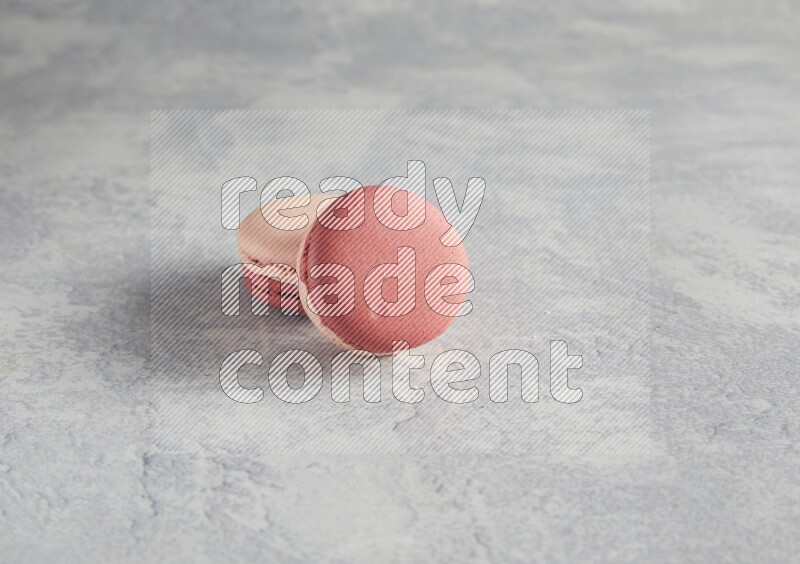 45º Shot of two Pink Litchi Raspberry macarons  on white  marble background