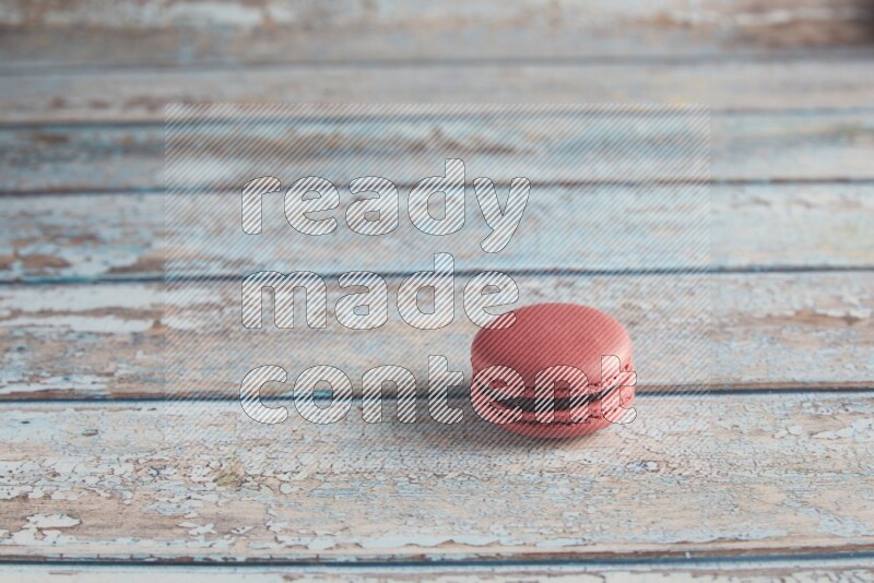 45º Shot of Pink Raspberry macaron on light blue wooden background
