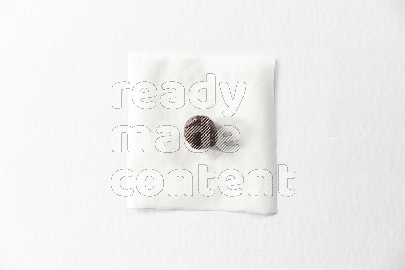 A dried plum on a piece of paper on a white background in different angles