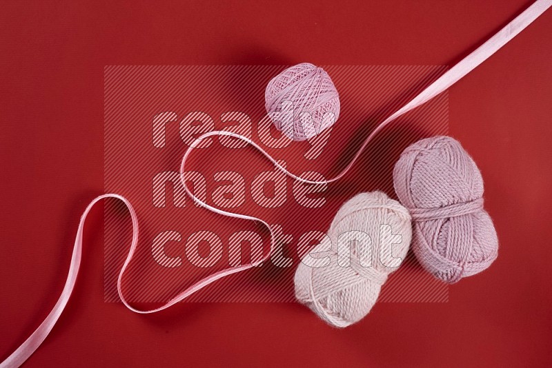Pink sewing supplies on red background