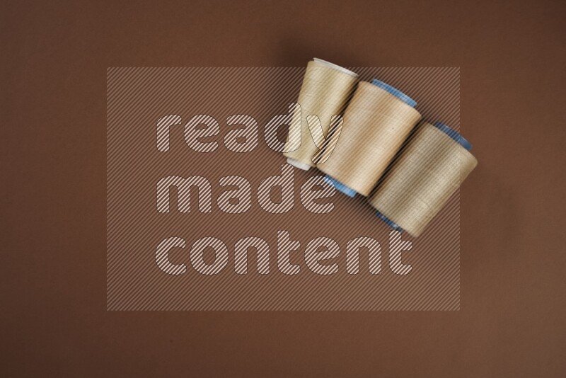 مجموعة من أدوات الخياطة والتفصيل بنية اللون على خلفية بنية