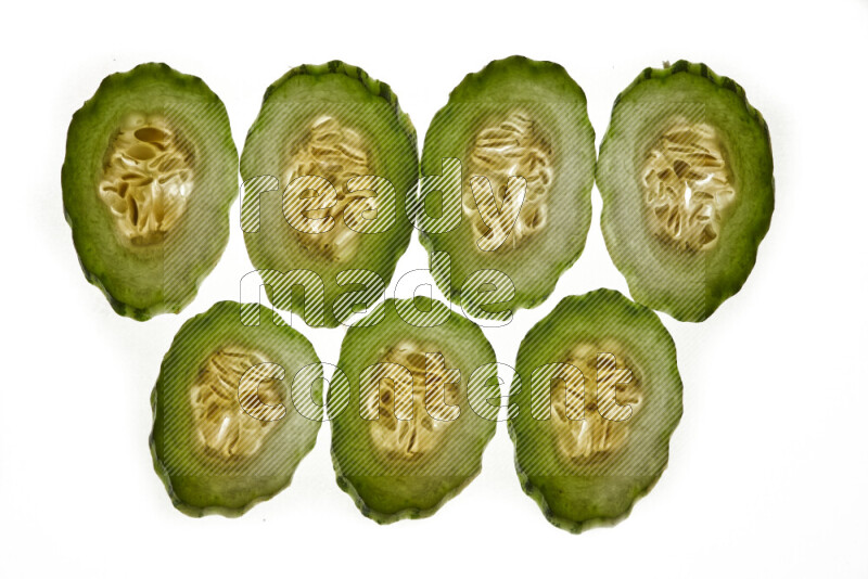Cucumber slices on illuminated white background