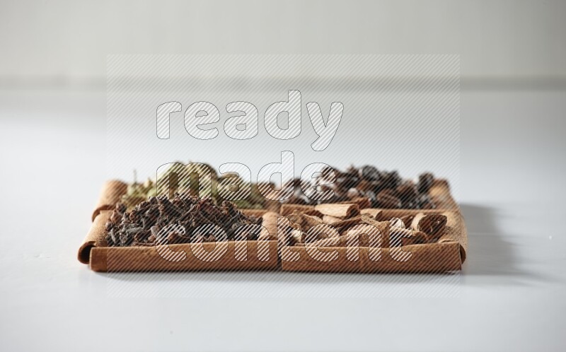 4 squares of cinnamon sticks full of coffee beans, cinnamon, cloves and cardamom on white flooring
