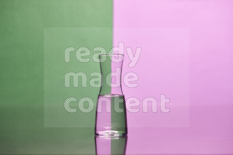 The image features a clear glassware filled with water, set against green and light purple background