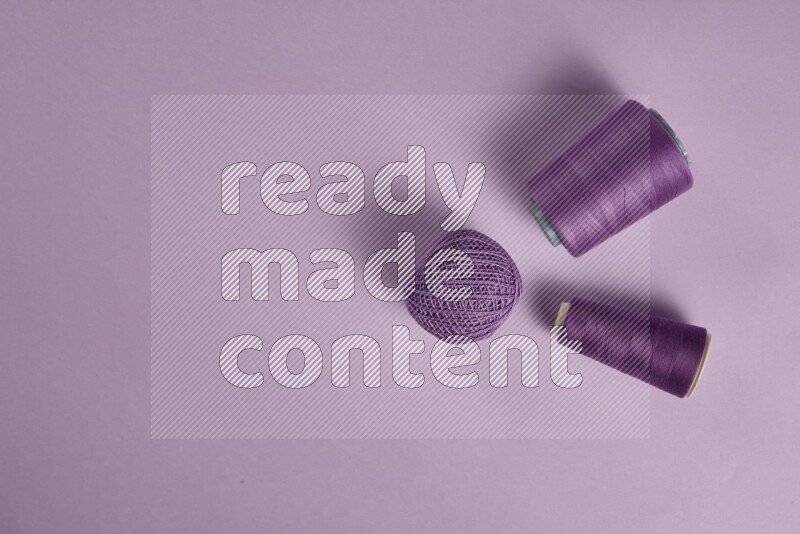 مجموعة من أدوات الخياطة والتفصيل أرجوانية اللون على خلفية أرجوانية