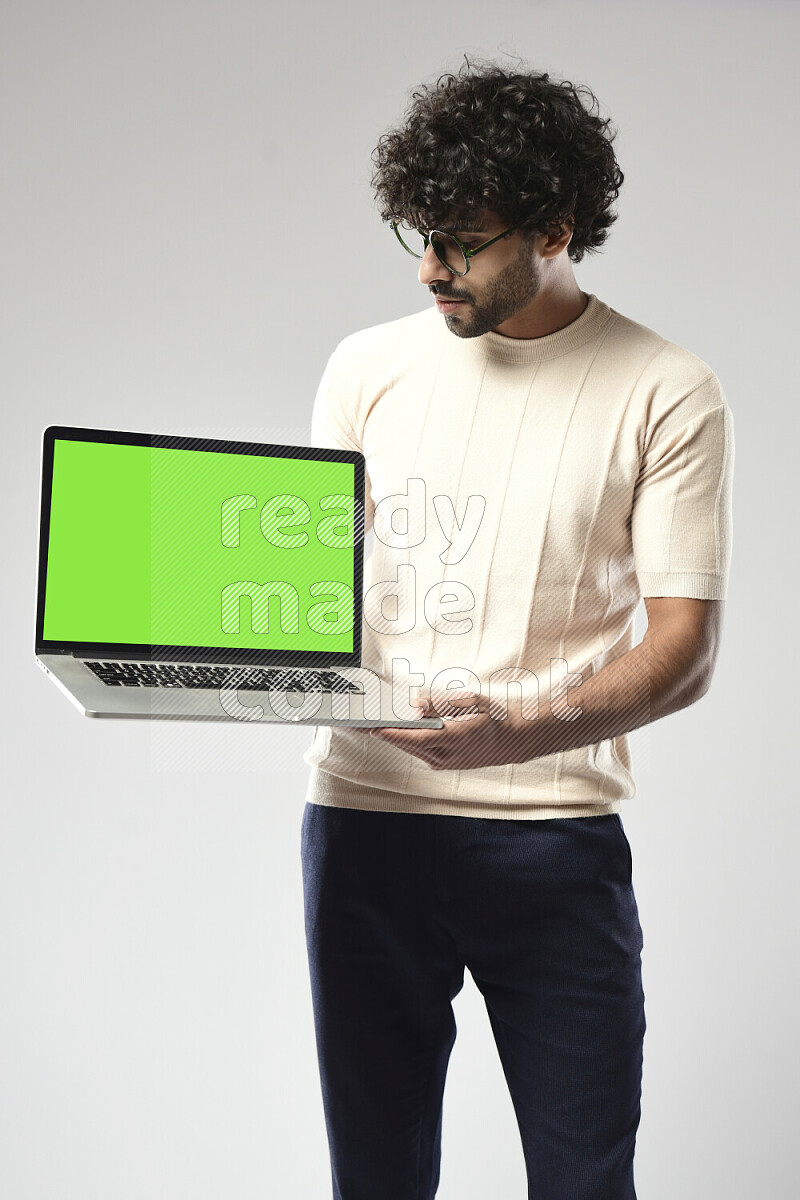 A man wearing casual standing and showing a laptop screen on white background