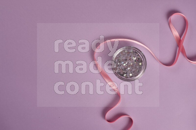 A pink and purple collection of sewing and tailoring tools arranged on a purple background