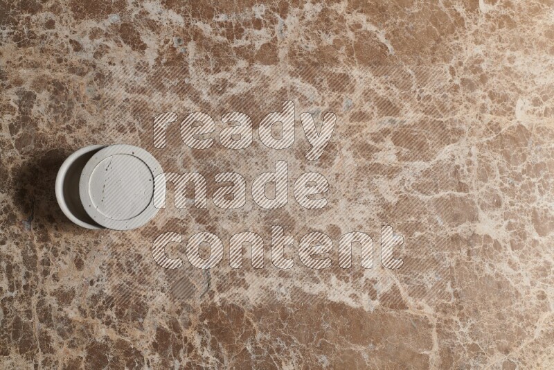 A pottery cup on beige marble background