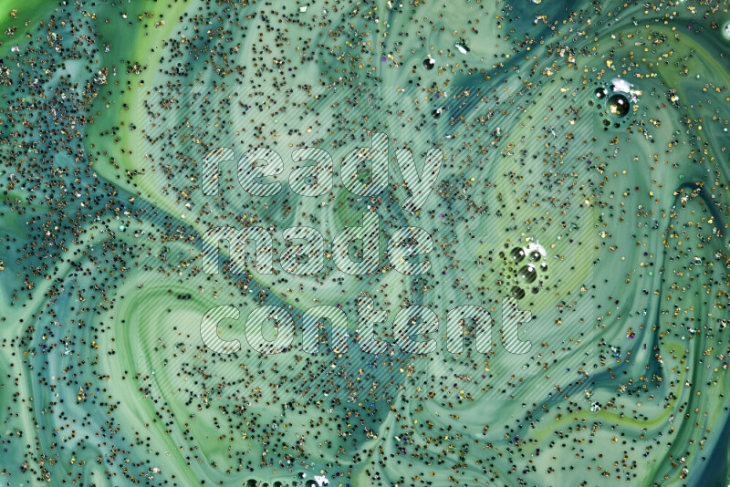 لقطة مقربة لبريق ذهبي متلألئ منتشر على خلفية من اللون الأخضر في حركات دائرية