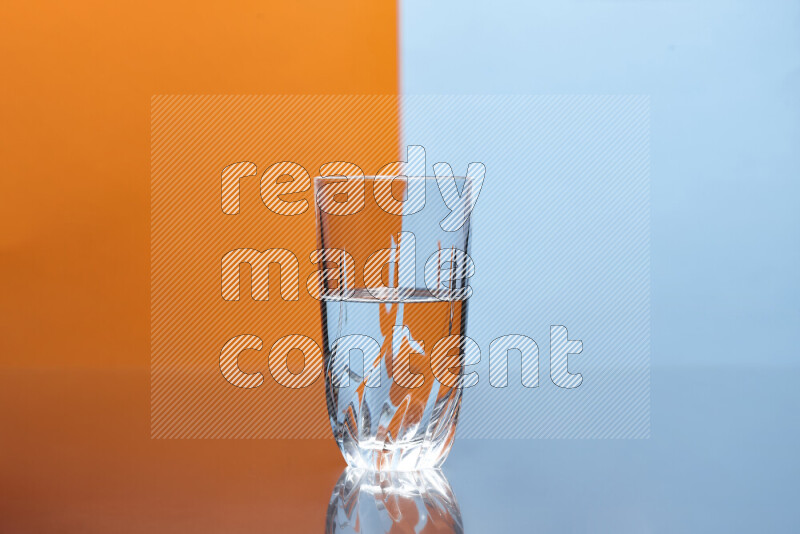 The image features a clear glassware filled with water, set against orange and light blue background
